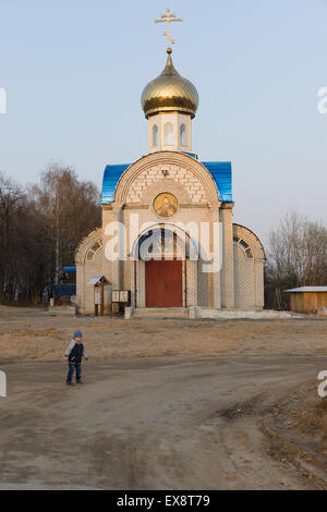 vor kurzem Postoroyenny Backsteinkirche mit einer goldenen Kuppel unter dem blauen Himmel Stockfoto