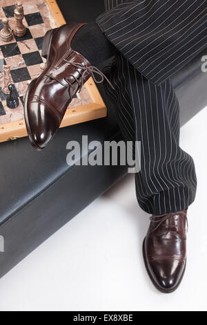 Mann Männer Menschen Hose Hose Schach Schach-Man Schach-Männer Studio spielen Spiel isoliert Hintergrund Möbel Sessel sitzen Stockfoto