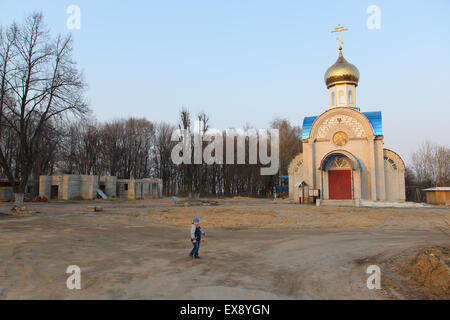 vor kurzem Postoroyenny Backsteinkirche mit einer goldenen Kuppel unter dem blauen Himmel Stockfoto