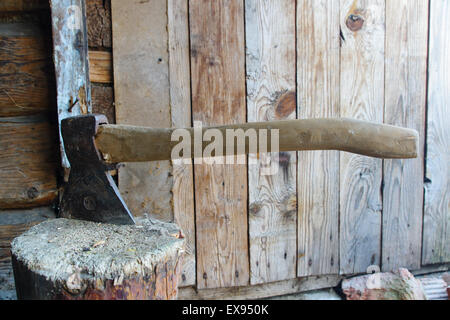 mächtige Axt mit Spuren von Rost wird in einem großen hölzernen Pack Schub. Stockfoto