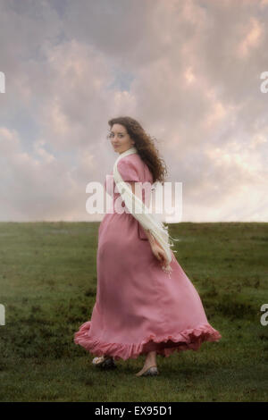 eine Frau in einem rosa Kleid ist Fuß bergauf Stockfoto