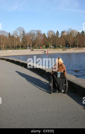 Frau mit einem Rollstuhl auf dem Stanley Park-Deich Stockfoto