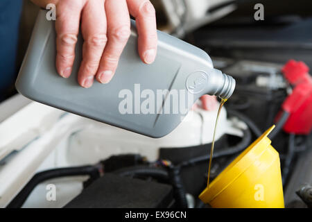 Man gießt Auto Öl aus Kunststoff-Flasche Stockfoto