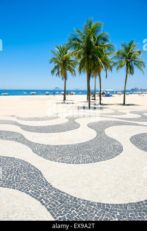 Kultige Bürgersteig Fliesenmuster mit Palmen am Copacabana Strand Rio de Janeiro Brasilien Stockfoto