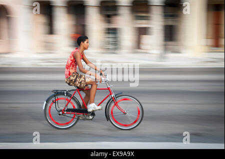 Havanna, Kuba - 13. Juni 2011: Junger kubanische Mann fährt Fahrrad entlang dem Malecon, Bewegungsunschärfe im Hintergrund. Stockfoto