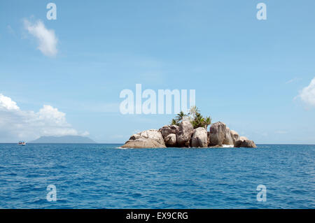 Eine kleine felsige Insel mit Palmen in der Nähe der Insel Mahé, Indischer Ozean, Seychellen Stockfoto