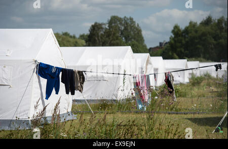 Hamburg-Wilhelmsburg, Deutschland. 9. Juli 2015. Kleidung hängen an einem Zaun vor Zelten, richten Sie auf dem Gelände der Auffanglager für Flüchtlinge in Hamburg-Wilhelmsburg, Deutschland, 9. Juli 2015. Die Hamburg Zustand Parlamentsdebatten über das Asylrecht unter anderem am 9. Juli 2015. Foto: DANIEL REINHARDT/Dpa/Alamy Live News Stockfoto