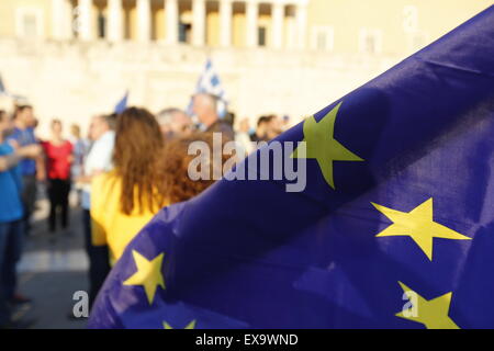 Athen, Griechenland. 9. Juli 2015. Ein Demonstrant trägt eine Europaflagge an pro-europäischen Protest in Athen. Tausende von Griechen protestierten vor dem griechischen Parlament gegen einen möglichen Grexit. Man nennt sie die griechische Regierung um sicherzustellen, dass Griechenland in Europa und in der Eurozone bleiben wird. Stockfoto