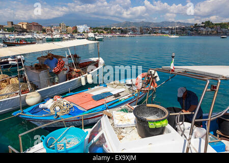 Fischer auf ihren Booten im Hafen von Giardini Naxos, Messina, Sizilien mit dem Ätna im Hintergrund arbeiten Stockfoto