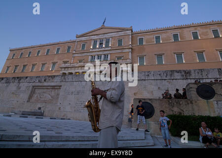 Athen, Griechenland. 9. Juli 2015. Ein Mann spielt die Nationalhymne mit einem Saxophon vor dem Parlament. Während die griechische Regierung Verhandlungen mit ihren Gläubigern mit dem Grexit Szenario noch sichtbar ist, zeigen Menschen zugunsten Griechenlands europäische Zukunft. Bildnachweis: Kostas Pikoulas/Pacific Press/Alamy Live-Nachrichten Stockfoto