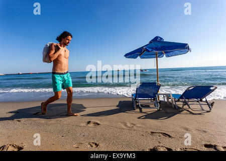 Mann, der allein am Strand von Rethymno, Kreta, Griechenland, läuft Stockfoto