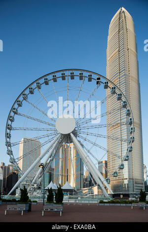 China, Hong Kong, Hong Kong Riesenrad ragt Central Piers mit IFC2 Gebäude und die Skyline der Stadt im Hintergrund auf Sonne Stockfoto