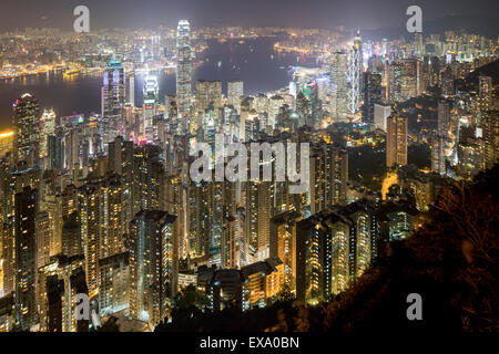 China, Hong Kong, Aussicht auf glühenden Wolkenkratzer in der Skyline der Stadt vom Aussichtspunkt auf dem Victoria Peak in der Dämmerung am Winterabend Stockfoto