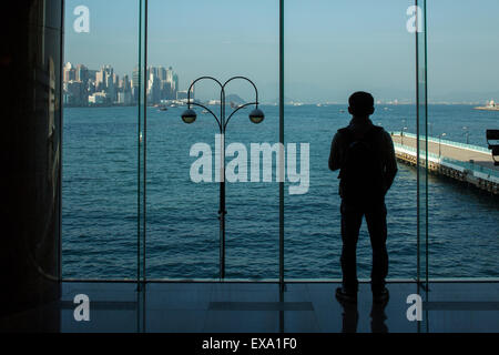 China, Hong Kong, Silhouette der Mann am Fenster der Hafen City Mall auf Kowloon Halbinsel auf Wintermorgen Stockfoto