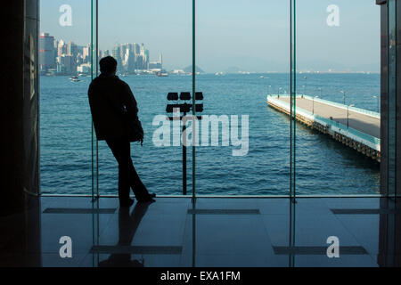 China, Hong Kong, Silhouette der Mann am Fenster der Hafen City Mall auf Kowloon Halbinsel auf Wintermorgen Stockfoto