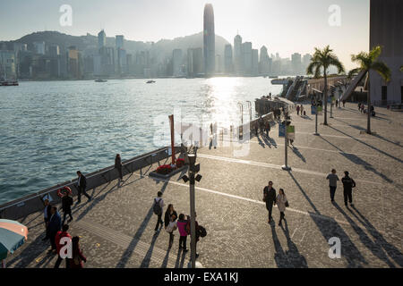 China, Hong Kong, Schattenwurf von Paaren zu Fuß entlang der Uferpromenade Uferpromenade in Tsim Sha Tsui auf der Kowloon-Halbinsel bei Sonnenuntergang auf Stockfoto