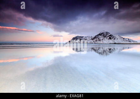 Sonnenuntergang am Skagsanden Strand, umgeben von schneebedeckten Berge spiegeln sich in den Meer, Flakstad, Lofoten, Arktis, Norwegen Stockfoto