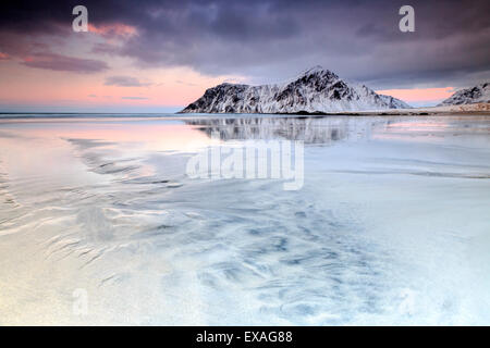 Sonnenuntergang am Skagsanden Strand, umgeben von schneebedeckten Berge spiegeln sich in den Meer, Flakstad, Lofoten, Arktis, Norwegen Stockfoto