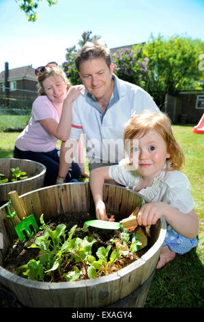 Eine Familie mit Tochter Pflanzen Samen in ihren Garten, Gloucestershire UK Stockfoto