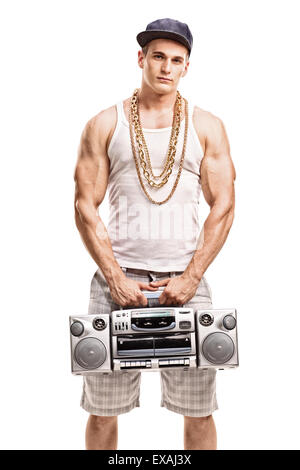 Vertikale Aufnahme eines muskulösen jungen Mannes im hip Hop Kleidung hält einen Ghetto-Blaster und schaut in die Kamera Stockfoto