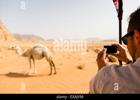 Wadi Rum Wüste, Jordanien. 9. Juni 2015. Europäische Touristen fotografieren vorbeigehen Kamel während Wüstentour. Stockfoto