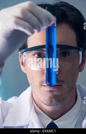 Chemiker hinterfragen Reagenzglas mit blauer Flüssigkeit Stockfoto