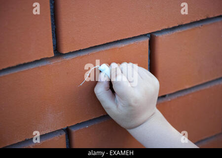 Childs Hand mit Kreide Zeichnung auf der Mauer Stockfoto