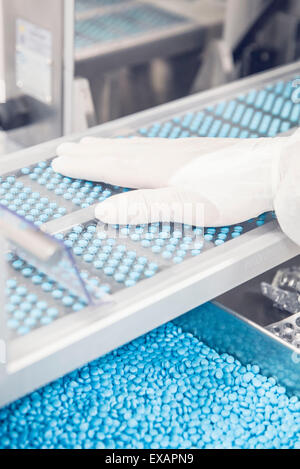 Arbeitnehmer Überwachung Pille Tabletts voran Förderband durch Verpackungsmaschine Stockfoto