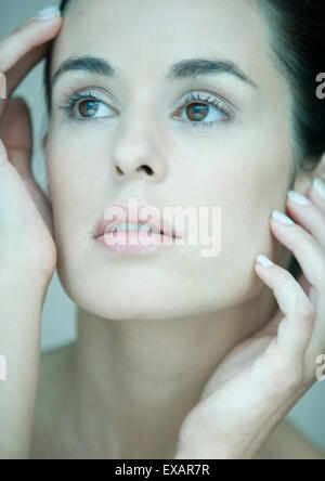 Frau, die Hände auf den Seiten des Gesichts, Porträt Stockfoto