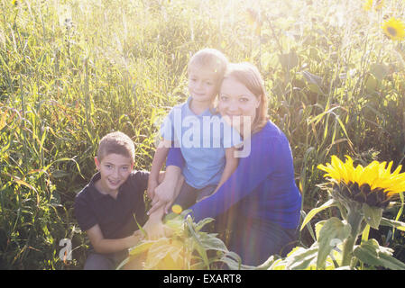 Mutter und junge Söhne zusammen im Feld von Sonnenblumen, Porträt Stockfoto