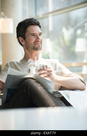 Mann mit Kaffee und Zeitung entspannen Stockfoto