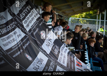 Eine Gruppe von heimischen Fans mit einem Banner gerade die erste Halbzeit-Aktion im Zeittraining die Europa League erste Runde, zweite Bein Unentschieden zwischen Bala Town aus Wales und FC Differdange 03 von Luxemburg. Es war der walisische Club zweite Staffel des Europäischen Wettbewerbs, und aufgrund der Boden-Vorschriften, die das Spiel am nahe gelegenen Belle Vue, Heimat von Rhyl FC gespielt wurde. Die Gäste gewannen die Krawatte 4-3 auf Aggregat durch einen Last-Minute Auswärtstor von Omar Er Rafik, in einem Spiel von 1039 Fans sahen und zum türkische Riesen Trabzonspor in der nächsten Runde zu spielen. Stockfoto