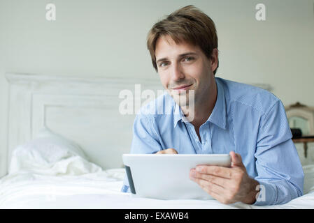 Mann im Bett mit digital-Tablette Stockfoto