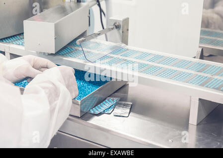 Techniker, die Pillen auf Förderband Eingabe Blisterpack Dichtungsmaschine Überwachung Stockfoto