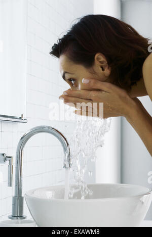 Frau beugte sich über Waschbecken waschen Gesicht, Seitenansicht Stockfoto