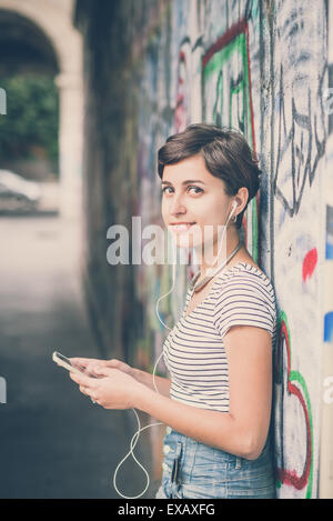 junge Hipster Frau anhören von Musik in der Stadt Stockfoto