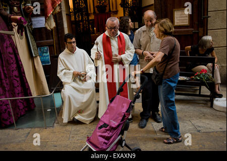 Segnen Sie im gotischen Viertel von Barcelona ein Priester den Warenkorb von einem ortsansässigen anlässlich des Heiligen Christophorus Stockfoto