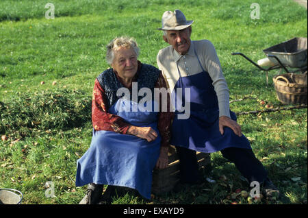 Grabe, Slowenien. Senioren Landwirtschaft paar mit blauen Schürzen in einem Feld. Stockfoto