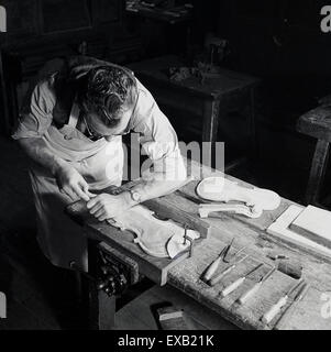 1950er-Jahren, historische, erwachsenen männlichen Handwerker an der Werkbank machen die Front und Rückseite eine Geige Stockfoto