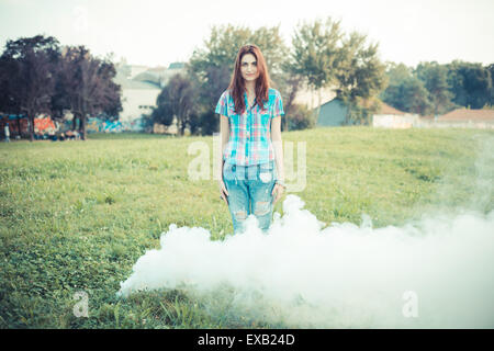 schöne junge Hipster Frau Rauch Nebel im park Stockfoto