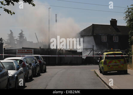 Croydon, Surrey Freitag, 10. Juli 2015 vier Feuer Motoren und rund 20 Feuerwehrleute waren aufgerufen, ein Feuer im Hof des Erbauers auf Fabrik Lane in Croydon heute Nachmittag das Feuer beteiligt rund zwei Tonnen lose verweigern und eine Butan Zylinder die Besatzungen abgekühlt.  Stationsleiter Sally Harper, die am Tatort sagte war: "das Feuer war gut entwickelt, als wir ankamen und unsere Crews hart gearbeitet, um es schnell in den Griff bekommen. Dank ihrer Bemühungen war das Feuer des Erbauers Yard beschränkt, obwohl wir ein Haus in der Nähe nur vorsorglich evakuiert. Bildnachweis: Jason Kay/Alamy Live News Stockfoto