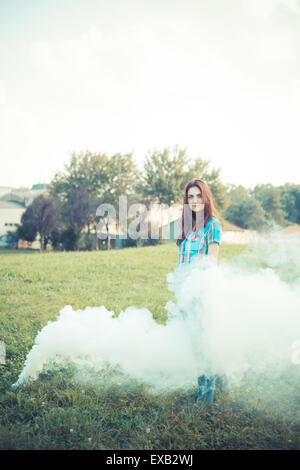 schöne junge Hipster Frau Rauch Nebel im park Stockfoto
