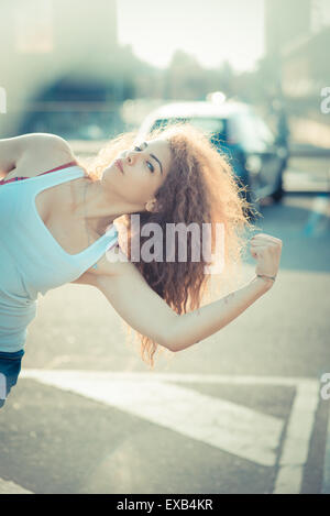 junge schöne langes lockiges Haar-Hipster-Frau in der Stadt Stockfoto