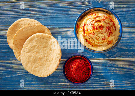 Hummus mit Pita Brot und rote Paprika Pulver am blauen Mittelmeer Holztisch Stockfoto