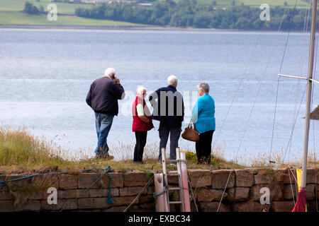 Gruppe von älteren Menschen stehen auf den Hafen Wand, Charlestown, Fife Stockfoto