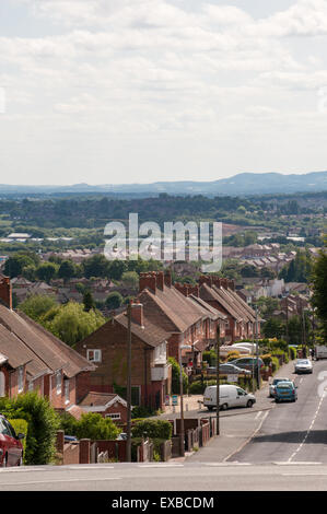 Blick auf eine Zersiedelung in Dudley mit Reihen von Rat Häuser entlang einer leeren Straße mit Shropshire Hügel in der Ferne Stockfoto