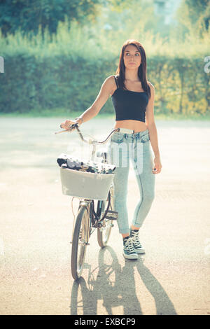 junge schöne Brünette glattes Haar Frau mit Fahrrad im freien Stockfoto