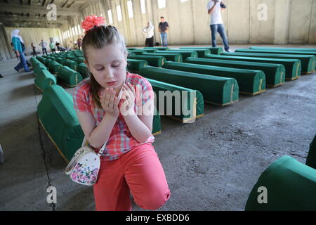 Srebrenica, Bosnien und Herzegowina. 10. Juli 2015. Eine Mädchen betet vor Särge in Potocari in der Nähe von Srebrenica, Bosnien und Herzegowina, am 10. Juli 2015. Am 11. Juli 2015, es wird sein eine feierliche Zeremonie zum 20. Jahrestag des Massakers von Srebrenica, die von angeblich einige 8000 muslimischen Männern und Kindern getötet wurden bosnisch-serbischen Kräfte in 1995. Bildnachweis: Haris Memija/Xinhua/Alamy Live-Nachrichten Stockfoto