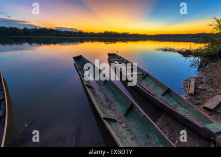 Dramatischen Sonnenuntergang in der Amazonas-Regenwald in Bolivien im Madidi Nationalpark mit zwei Kanus im Vordergrund Stockfoto