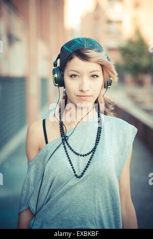 junge schöne Modell Frau Musik hören in der Stadt Stockfoto